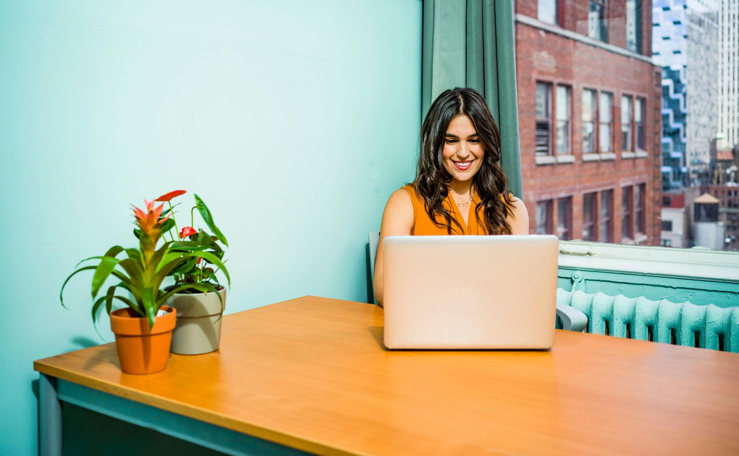 Woman behind laptop in shared office environment.